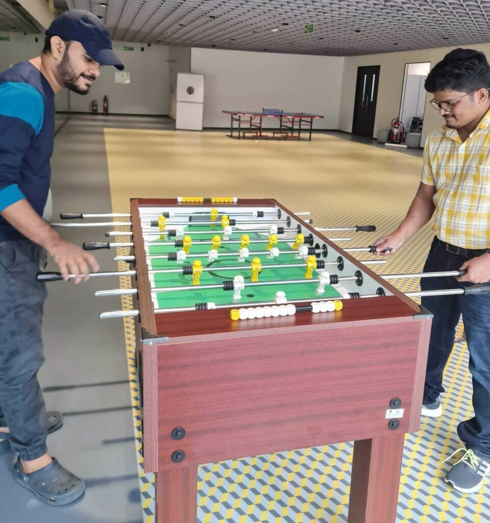 Utsav and his colleague playing foosball at Swiggy.